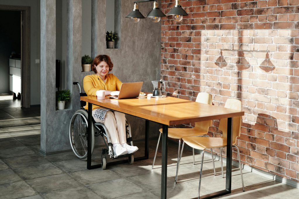 a person in a wheelchair working on a laptop at a desk